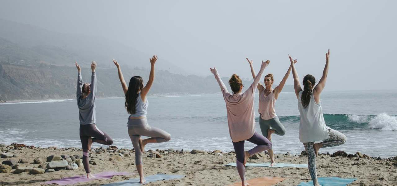Mujeres haciendo yoga en la playa
