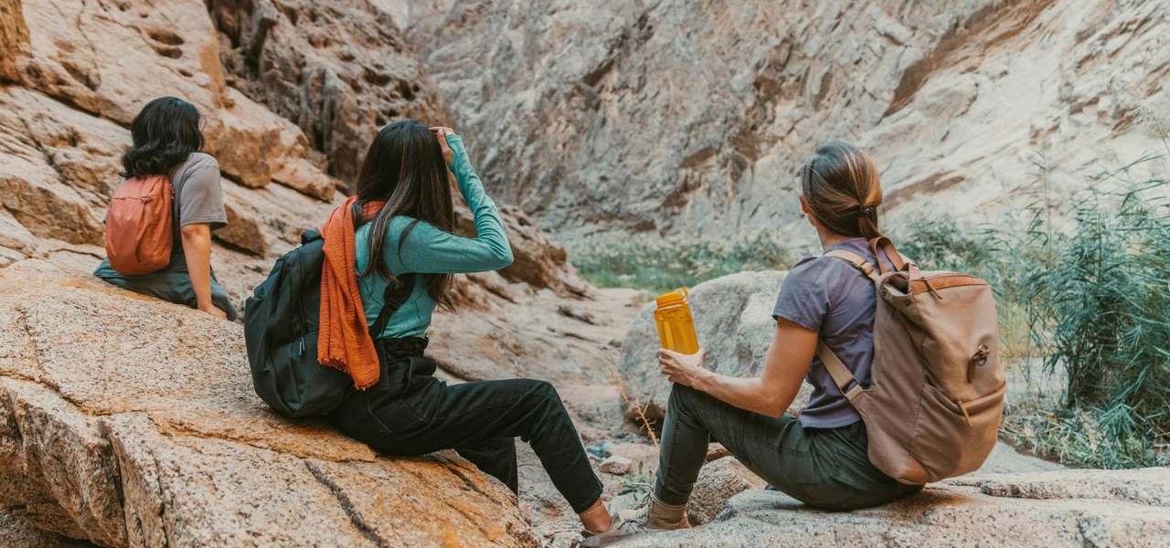 Mujeres sentadas en una caminata entre rocas